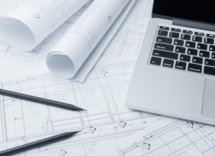 black pencil and computer laptop on architectural drawing paper for construction